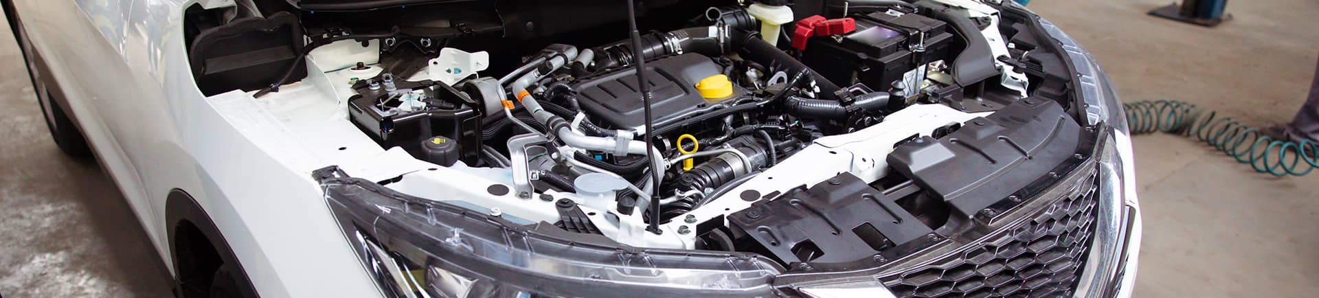 A photo of a car with the hood open at a mechanic's shop