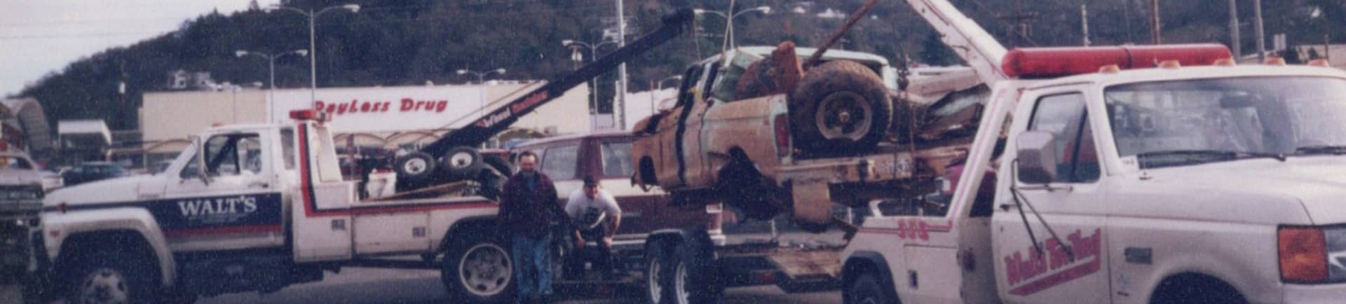 An old photo of Walt's Towing trucks towing a truck that has been in an accident in Roseburg, OR