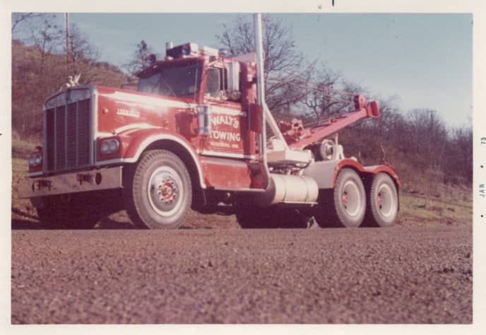 An old photo of a large red Walt's Towing tow truck from 1973